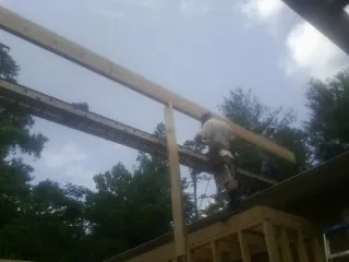 Carpenter setting a ridge beam over a new addition frame — Ice Dam Removal by Roofing Brothers in Wisconsin Dells