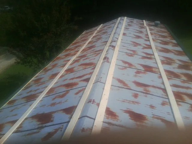 Rusted metal roof panels with new wood purlins before replacement — Storm Damage Roof Repair in Wisconsin Dells by Roofing Brothers