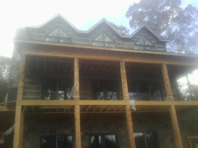 Dormers and porch framing on a large log home under construction — Roof Coating work by our crew in Wisconsin Dells