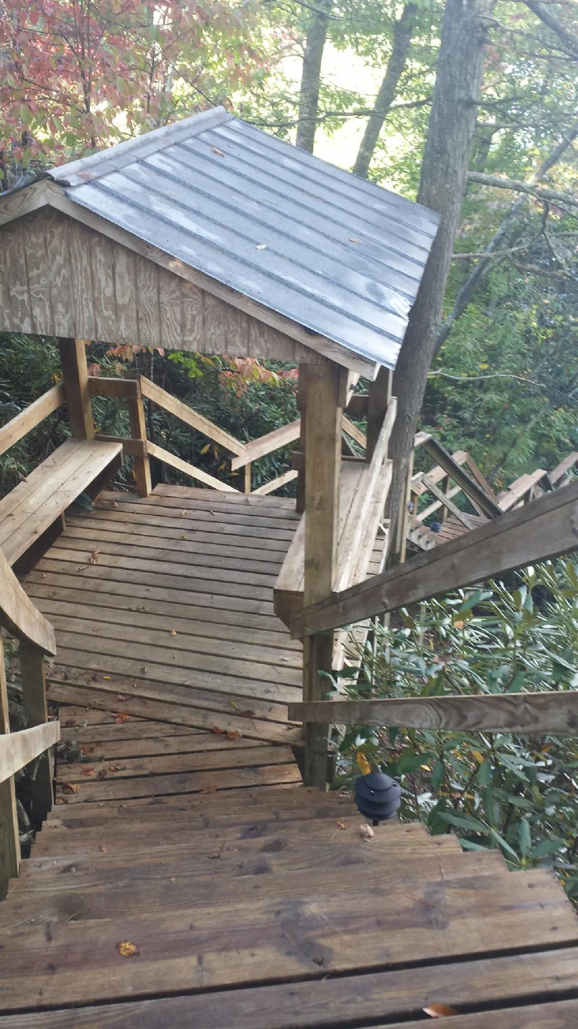 Metal roofed shelter over wooden steps on a wooded walkway — Skylight Repair & Installation work by our crew in Wisconsin Dells