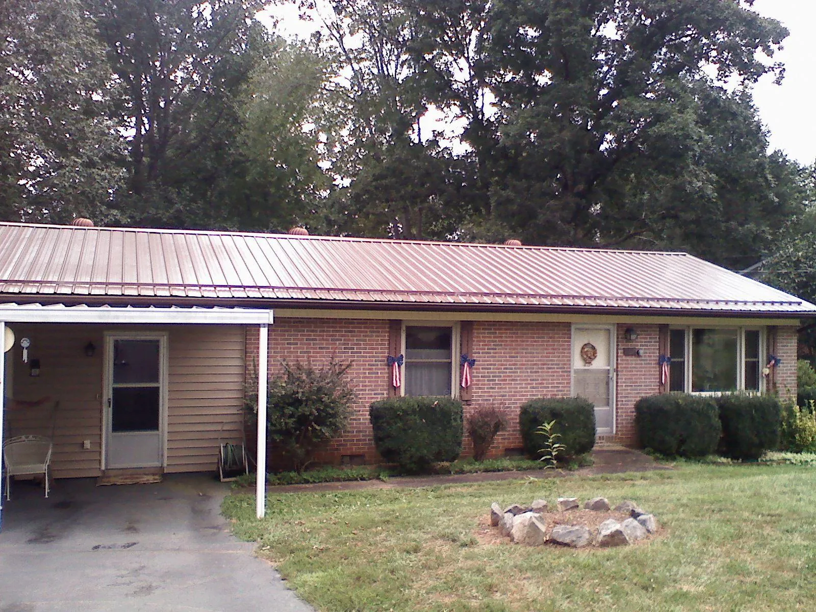 Bronze metal roof and carport on a brick ranch home — Roof Repair work by our crew in Wisconsin Dells