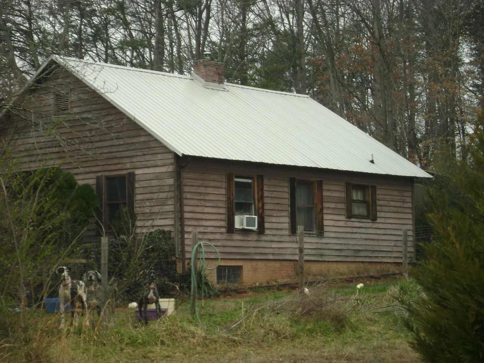 White metal roof on an old wood sided farmhouse, from a Metal Roof Installation job in Wisconsin Dells